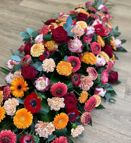 Dessus de cercueil de roses, gerberas et œillets aux couleurs vives