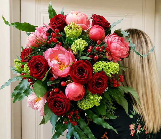 Bouquet de roses rouges et de pivoines roses offert pour une fête