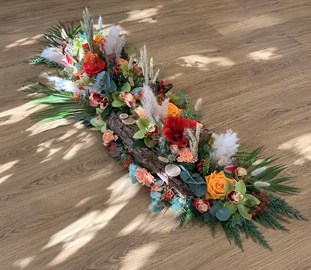 Dessus de cercueil fleuri de roses, gerberas et feuillages