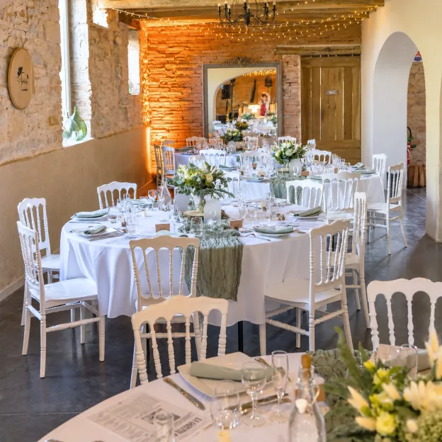 Salle de réception de mariage dressée et fleurie de compositions blanches